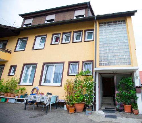 a yellow house with a table in front of it at Hotel Fantastic in Neckartenzlingen