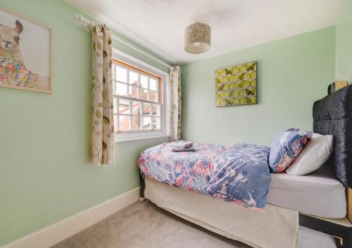 a bedroom with a bed and a window at Puddingmoor Cottage in Beccles