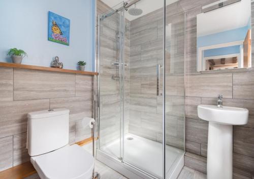 ein Bad mit einer Dusche, einem WC und einem Waschbecken in der Unterkunft Puddingmoor Cottage in Beccles