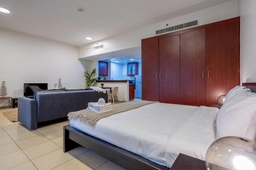 a large bedroom with a large bed and a couch at Big Studio in Rimal at The Beach JBR in Dubai