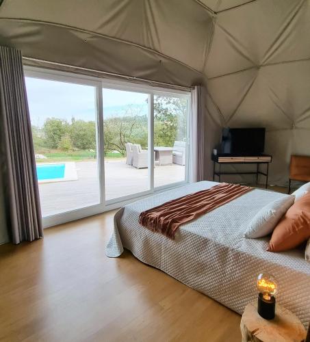 a bedroom with a bed and a large window at Pura - Home in Nature in Oliveira do Hospital