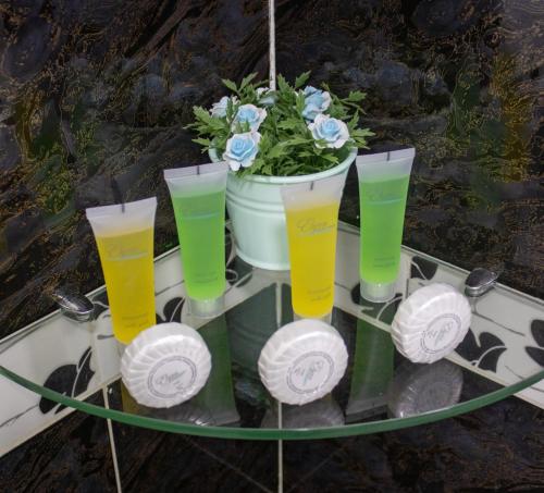 a glass table with four glasses and a potted plant at The Castle Hotel in Amman