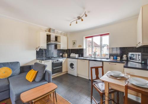 a kitchen and living room with a couch and a table at The Little Hopton in Saxmundham