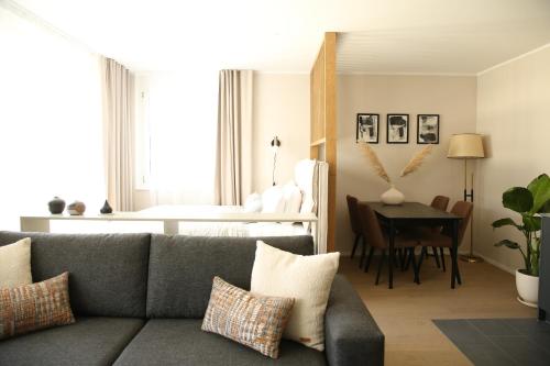 uma sala de estar com um sofá e uma mesa em Lamira - Serviced Apartments em Zurique