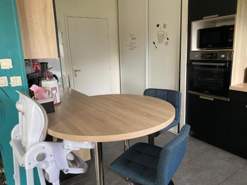 - une cuisine avec une table et des chaises en bois dans l'établissement Maison cosy Arnage, à Arnage