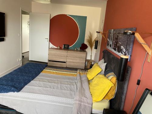 een slaapkamer met een bed met gele kussens bij Maison cosy Arnage in Arnage