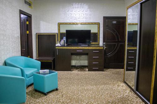 a living room with a television and a mirror at The Castle Hotel in Amman