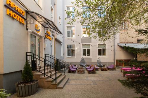 einen Innenhof eines Hotels mit lila Stühlen und einem Gebäude in der Unterkunft Stories Hub in Lwiw
