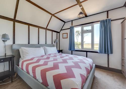 a bedroom with a bed and a window at Beach House in Southwold