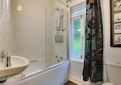 a bathroom with a sink and a shower and a window at Arthog Hall Farm in Arthog