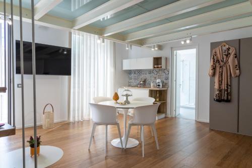 a dining room with a white table and chairs at Peonia Boutique Apartments in Palermo