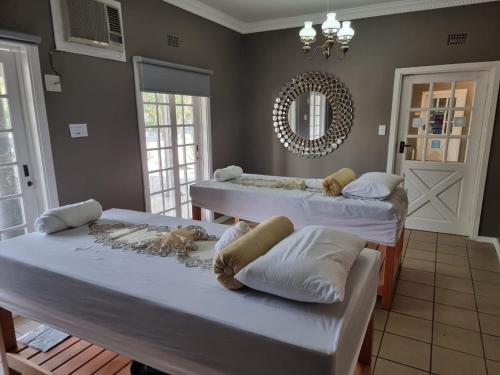 two beds in a room with a mirror at Crayfish Creek Guest House in Richards Bay