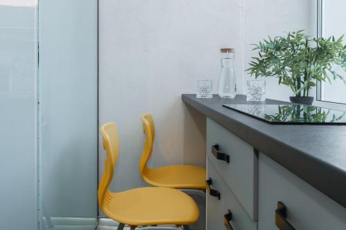 two yellow chairs sitting at a counter in a kitchen at Stories Hub in Lviv