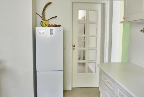 a white refrigerator in a kitchen with a door at Ljmonade Hostel in Cascais