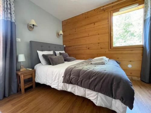 a bedroom with a large bed with a wooden wall at Appartement 4 chambres avec grande terrasse in Les Deux Alpes
