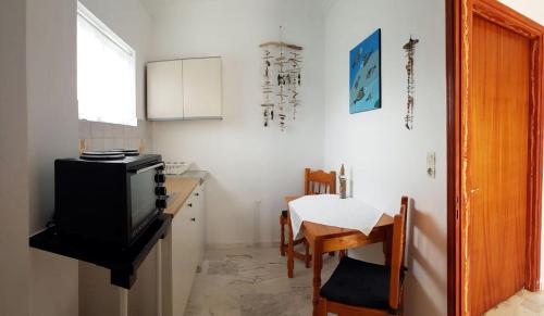 cocina con mesa y TV en una habitación en ILEKTRA Apartments Blue & Red, en Plataria