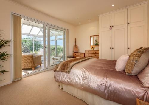 a bedroom with a bed and a sliding glass door at Bryn in Abersoch