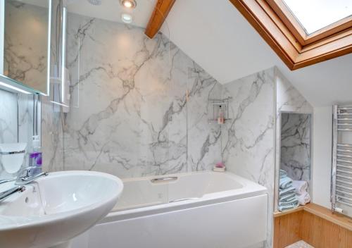 een badkamer met een wit bad en een wastafel bij Bryncylla in Llangurig