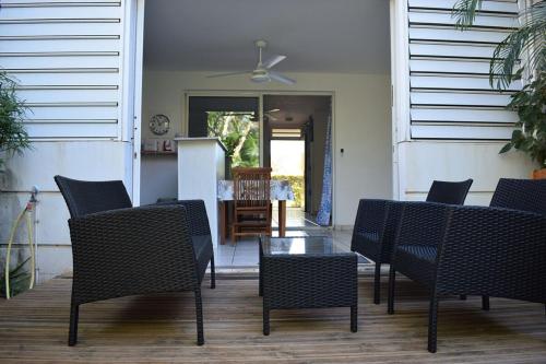 un patio con sillas y una mesa y una cocina en Studio Tamarin lagon de trou d'eau, en La Saline-Les-Bains