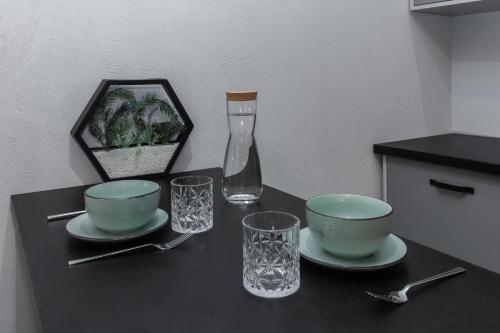 a table with two bowls and a vase and glasses at Stories Hub in Lviv