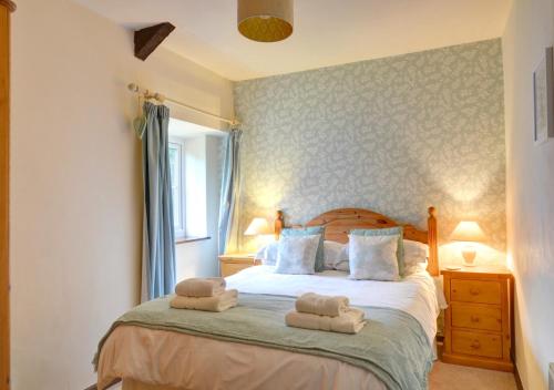 a bedroom with a bed with towels on it at Swallow Cottage in Llanerchymedd