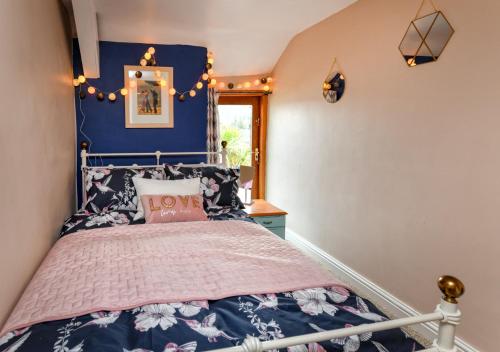 a bedroom with a bed with a blue wall at Ty Ni in Nefyn
