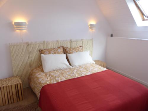 1 dormitorio pequeño con 1 cama con manta roja en gite d'artiste le lézard vert, en Scrignac