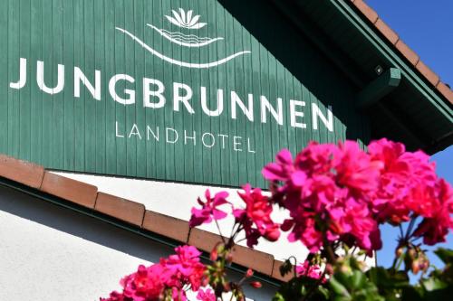 een bord met roze bloemen voor een gebouw bij Landhotel Jungbrunnen in Bad Brambach