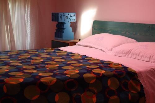a bedroom with a bed with a colorful blanket on it at Holiday Home Natural Art House in Višnjan