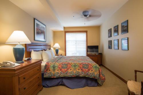 a bedroom with a bed and a desk with a telephone at 3221 - Three Bedroom Standard Powderhorn Lodge condo in Solitude