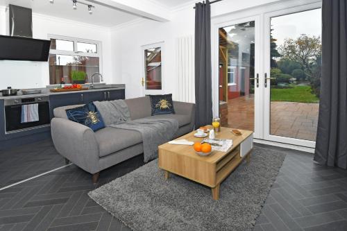 a living room with a couch and a table at Moonlight House - sleeps 7, driveway, garden in Crewe