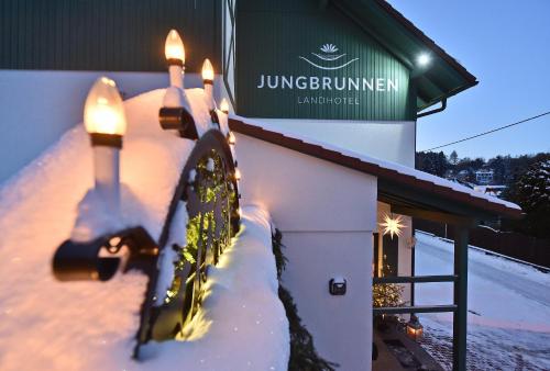 a snow covered building with lights in front of it at Landhotel Jungbrunnen in Bad Brambach