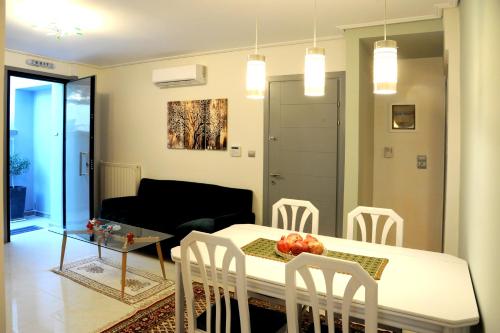 a dining room and living room with a table and chairs at Olive and Orange Apartment in Mystras