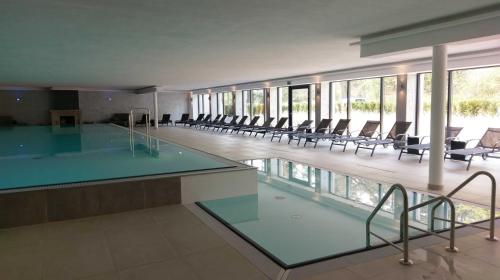 a large swimming pool with chairs in a building at Meerblick Appartement Ostseebad Binz Prora direkt am Strand in Binz