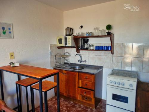 a small kitchen with a sink and a stove at Dunas del Diablo in Punta Del Diablo