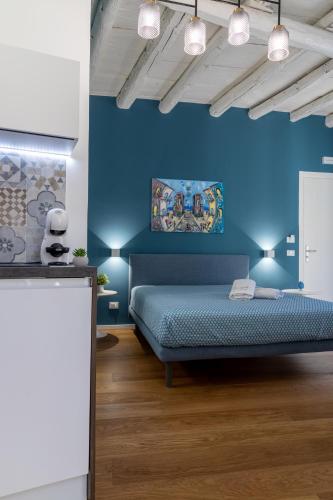 a blue bedroom with a bed and a blue wall at Peonia Boutique Apartments in Palermo