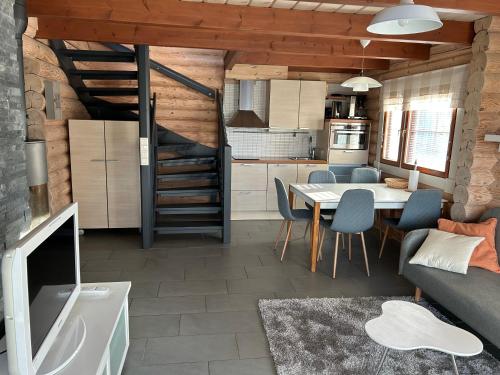 a kitchen and dining room with a table and chairs at Villa Laakson Helmi 1 с камином, сауной, SPA, на берегу озера in Himos