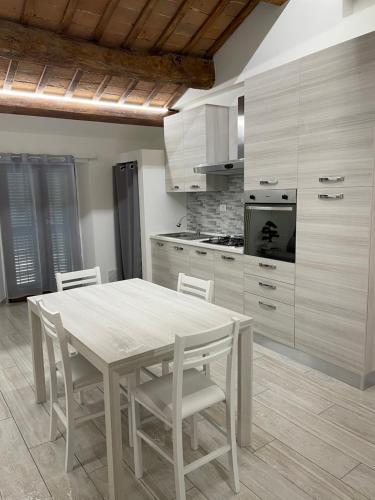 uma cozinha com mesa e cadeiras num quarto em Appartamento "IL PORTICO" A SOLI 8 CHILOMETRI DA IMOLA E 7 CHILOMETRI DA FAENZA em Castel Bolognese