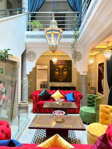 a living room with a red couch and a face on the wall at Villa Margaux in Essaouira