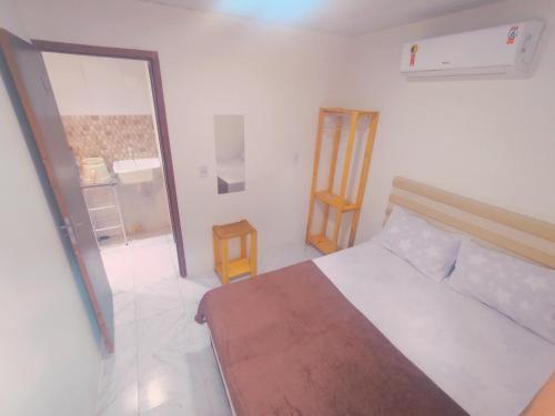 a white bedroom with a bed and a glass door at Casa de praia Rocha Alves em Porto de Galinhas in Porto De Galinhas