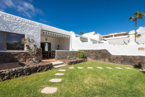 a white house with a lawn in front of it at Casa Silvia, casa con jardín y vista al mar in Costa Calma