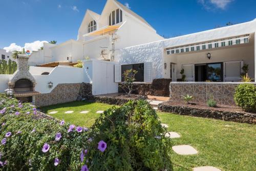 a house with a garden in front of it at Casa Silvia, casa con jardín y vista al mar in Costa Calma
