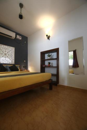 a bedroom with a yellow bed and a window at Craft Hostels in Anjuna