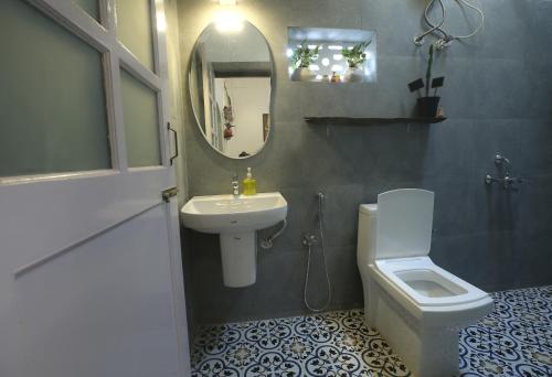 a bathroom with a sink and a toilet and a mirror at Craft Hostels in Anjuna