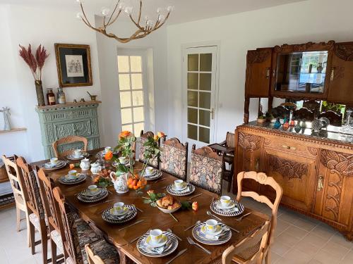 ein Esszimmer mit einem Holztisch mit Essen drauf in der Unterkunft Villa Opale Etretat in Étretat