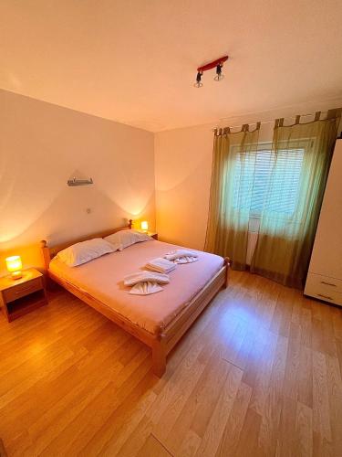 a bedroom with a large bed and a wooden floor at Apartments Anita and Zoran in Stanići
