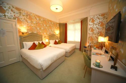 a hotel room with two beds and a window at Kilronan House in Dublin