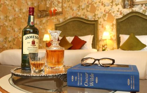 a bottle of wine on a table with a book and glasses at Kilronan House in Dublin