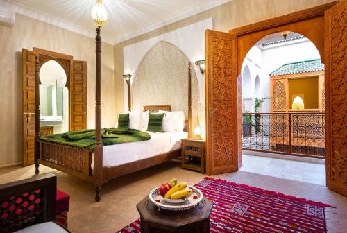 Palais Tara & Spa في مراكش: غرفة نوم مع سرير مع وعاء من الفواكه على طاولة