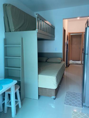 a small bedroom with a bunk bed and a table at Lindo Studio Matinhos Prédio na beira mar. in Matinhos